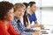 Multi racial teenage pupils in class, one smiling to camera