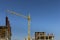 A multi-storey apartment building is being constructed using tower cranes that can reach heights as the work progresses