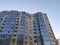 A multi-storey house against a blue sky. A new modern apartment building with glass balconies. Residential area. Realty. Copy