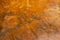 multi toned close up of semi smooth weathered golden orange stucco wall texture background