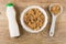 Multicereal flakes in bowl, spoon with flakes, napkin, yogurt