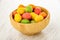 Multicolor dragee with peanut in bowl on wooden table