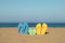 Multicolor flip-flops on the sandy baech against sea and sky