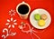 Multicolor macaroon cookies, coffee cup and the heart sign on the bright red napkin with flowers