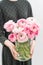 Multicolor pink buttercup, Ranunculus in a vase in woman hand. the work of the florist at a flower shop .