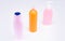 Multicolor plastic refillable liquid toiletry product containers in row, bottles