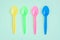 Multicolor plastic spoons on green background