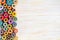 Multicolor sewing threads on white wooden background with copy space