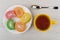 Multicolor spiral marmalades in plate, cup of tea, spoon