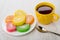 Multicolor spiral marmalades in plate, cup with tea, teaspoon