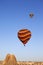 Multicolor striped hot air balloons on clear sunlit sky