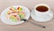 Multicolor Turkish delight in plate and cup of hot tea