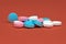 Multicolor vitamins drugs pink, blue and white on orange-brown background