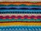 Multicolor wool crochet stitches blanket textile in bright colors background texture