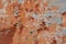 Multicolored background:concrete surface with peeling and cracked brown paint Natural defects Scratches cracks crevices chips dust