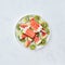 Multicolored berry frozen smoothies lolly with pieces of kiwi, lime, watermelon and ice cubes in a plate on a gray