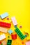 Multicolored blocks of the children`s constructor lie on yellow background. Space for text