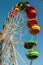 Multicolored booths of the devils wheel against the blue sky