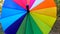 Multicolored bright umbrella spin around closeup. Slow motion