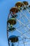 Multicolored carousel Ferris wheel on a blue sky background