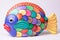 Multicolored ceramic fish on white background