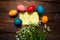 Multicolored chicken, painted eggs for the Easter holiday with lilies of the valley and leaf with the inscription Happy Easter on