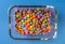 Multicolored chocolat candy in rectangle glass bowl background, copy space, close up