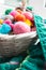 Multicolored clews in wicker basket with plaid closeup