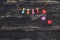 Multicolored clothespins of a heart on a string on a dark wooden background. Valentine`s Day