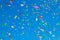 multicolored confetti on clear blue sky background