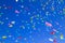 multicolored confetti on clear blue sky background