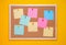 Multicolored corkboard stickers pinned with buttons. yellow background