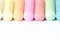 Multicolored crayons, pastel. Green, yellow, pink, purple, blue. Painted Pastels white blackboard