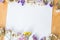 Multicolored dried flowers on wooden background, colorful limonium statice plant with copy space, blank white paper with place for