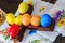 Multicolored eggs decorated for Easter holiday. Row of colorful Easter eggs on rustic wood cross and wooden table. Top view of