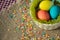 Multicolored eggs in easter festive basket on canvas napkin