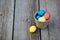 Multicolored eggs in a wicker basket on a wooden background