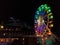 Multicolored ferris wheel in the square of Gubbio and big Christmas tree, Umbria, Italy