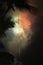 multicolored fireworks with palm fronds in the foreground