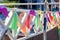 Multicolored flags on a fence.