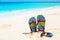 Multicolored flip-flops and sunglasses on a sunny beach.Tropica