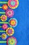 Multicolored flowers on a blue felt sheet. DIY design and decor. Sew on bright flowers. Holiday background