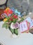 Multicolored fresh flowers bouquet and paper decorations in a vase on a table and tag with words still single. Wedding table