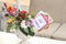 Multicolored fresh flowers bouquet and paper decorations in a vase on a table and tag with words still single. Wedding table