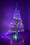 Multicolored garland on a Christmas tree luminous with magic small decorative glass tree with illumination in the dark