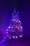 Multicolored garland on a Christmas tree luminous with magic small decorative glass tree with illumination in the dark