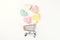 Multicolored hearts fall into mini shopping cart, flat lay, top view. Shopping, sales and marketing concept