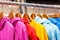Multicolored hoodies on hangers in a sports store close-up