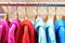 Multicolored hoodies on hangers in sports store close-up, side view