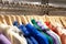 Multicolored hoodies on wooden hangers in sports store close-up